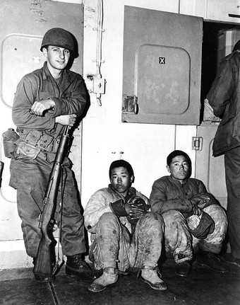 U.S. Marine guards North Korean POWs aboard ship, 1951, author unknown.